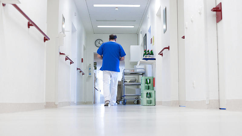 ARCHIV - Ein Krankenpfleger geht am 22.11.2012 über einen Flur im Krankenhaus von Salzhausen (Niedersachsen). Viele Krankenhäuser stehen vor der Pleite, nicht nur in Niedersachsen. Vor allem kleinere Kliniken könnten zum Auslaufmodell werden. Auf dem