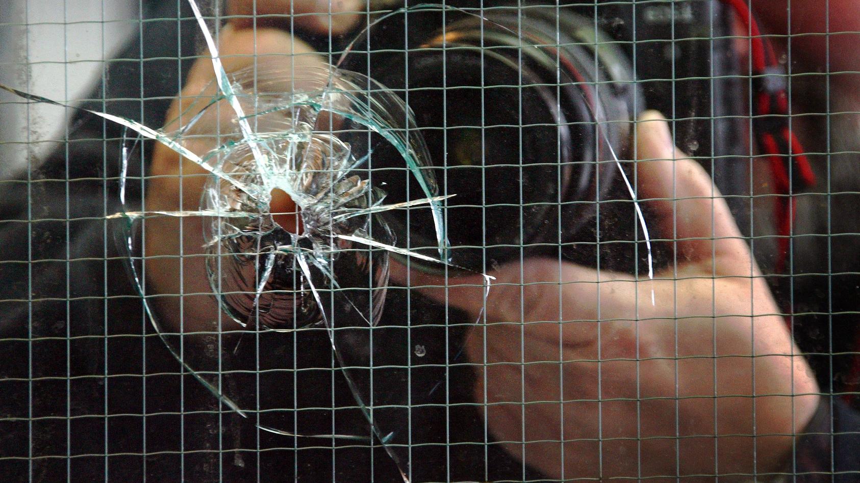 ARCHIV - Ein Bildjournalist fotografiert in Düsseldorf ein Einschussloch im Fenster einer Diskothek (Archivfoto vom 23.03.2007). Bei einer Schießerei vor dem Tanzlokal waren zuvor drei Menschen verletzt worden. Am Dienstag (08.05.2007) wird in Berlin