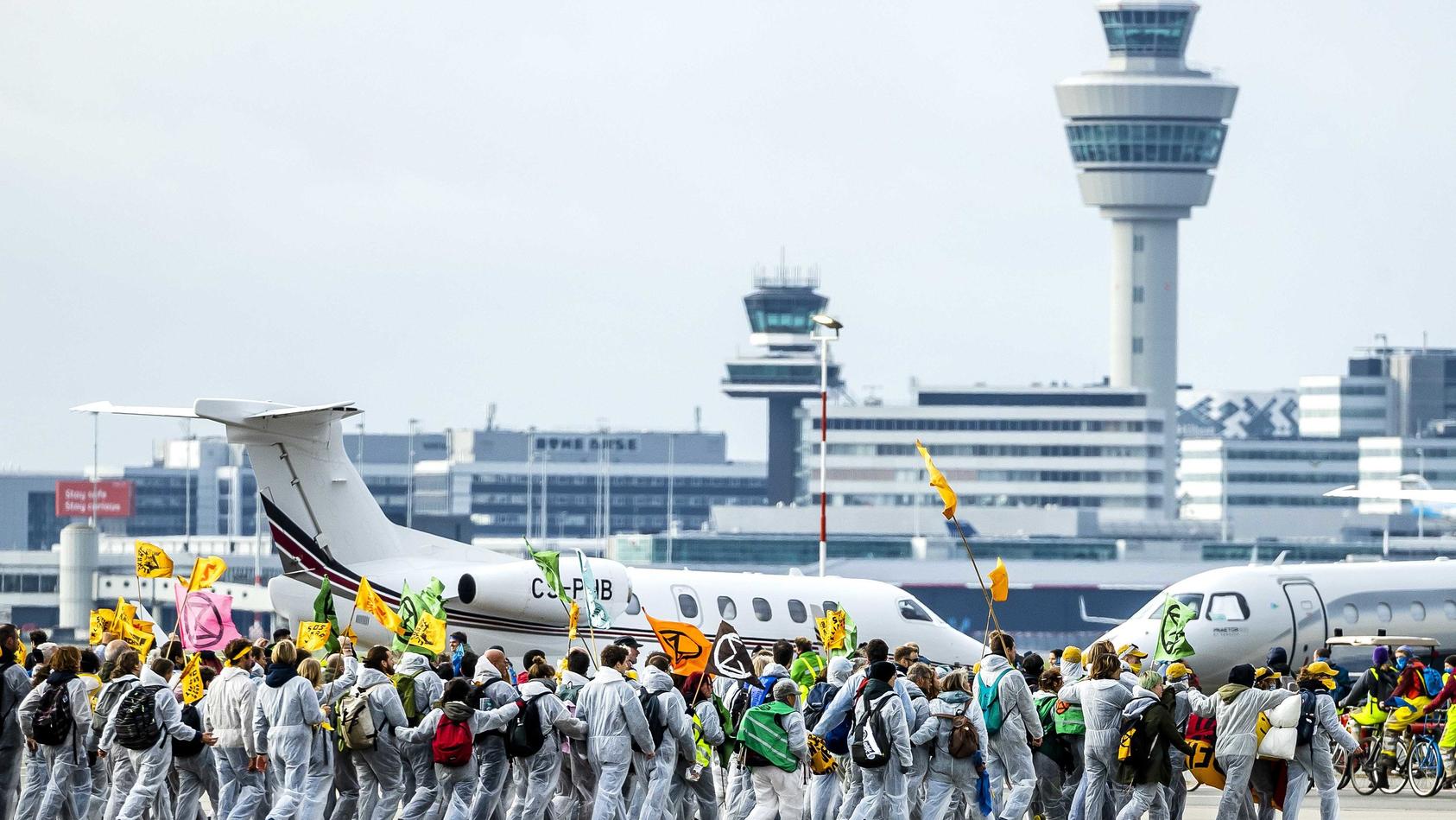 dpatopbilder - 05.11.2022, Niederlande, Amsterdam: Aktivisten verschiedener Umweltvereine führen die Protestaktion «SOS für das Klima» auf dem Flughafengelände vom Flughafen Schiphol durch. Unter anderem haben sich Milieudefensie, Extinction Rebellio