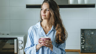 Frau trinkt Kaffee am Morgen im Pyjama