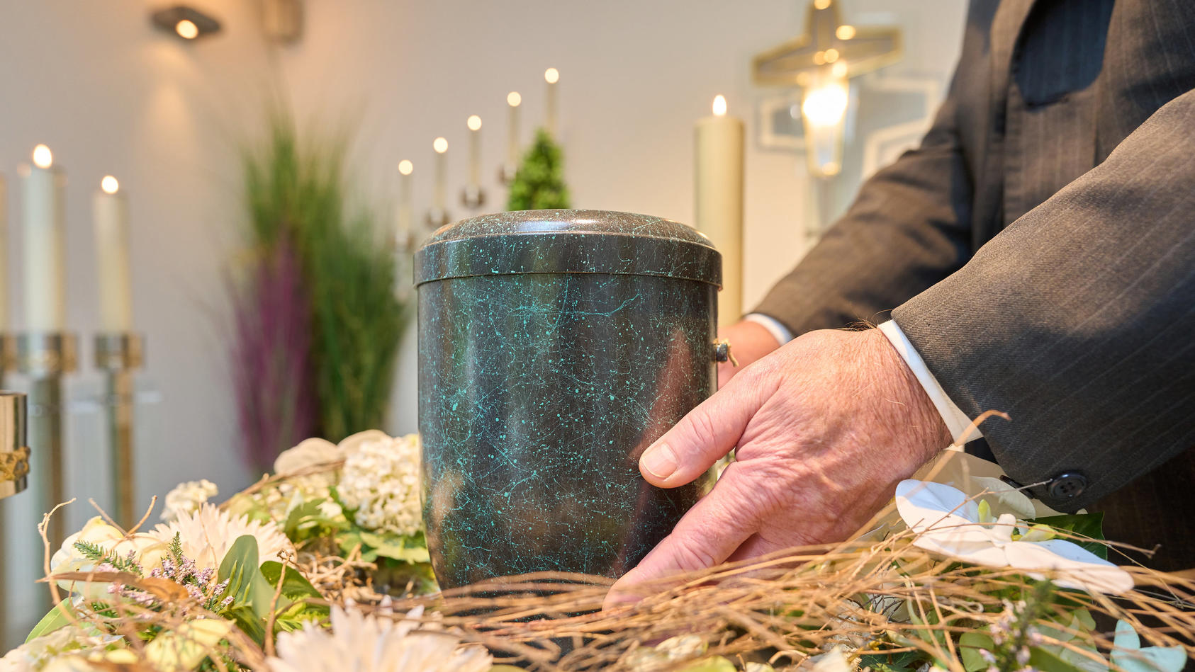 Bestatter platziert eine Urne im Andachtsraum 