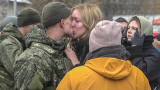 Ein Soldat küsst eine Frau zum Abschied auf den Mund