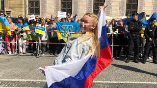 Julia P. posiert mit russischer Flagge in München vor Teilnehmern einer Pro-Ukraine-Demo. Nach ihrem Auftritt gingen mehrere Strafanzeigen bei diversen Polizeibehörden ein.