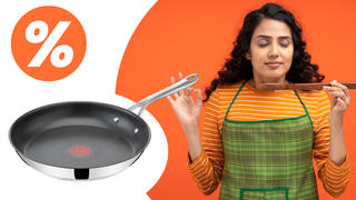 Eine Frau die an einem Kochlöffel riecht und die Jamie Oliver Pfanne auf weiß-orangen Hintergrund mit einem Prozentzeichen in der linken Ecke.