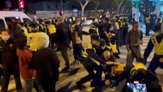 Police officers detain people during a protest against coronavirus disease (COVID-19) curbs at the site of a candlelight vigil for victims of the Urumqi fire, in Shanghai, China in this screengrab obtained from a video released on November 27, 2022. Video obtained by Reuters/via REUTERS  THIS IMAGE HAS BEEN SUPPLIED BY A THIRD PARTY. NO RESALES. NO ARCHIVES.