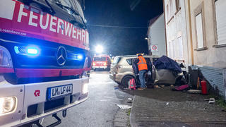 25.11.2022, Hessen, Brechen: Fahrzeuge der Feuerwehr sind nach einem Unfall im Einsatz. Eine 32 Jahre alte Mutter ist in Brechen-Werschau (Landkreis Limburg-Weilburg) bei dem Unfall ums Leben gekommen, als der Wagen ihrer Familie gegen eine Hauswand prallte. Ihre Kinder im Alter von zwölf, acht und einem Jahr sowie der 34-jährige Vater wurden schwer verletzt, wie die Polizei mitteilte. Foto: Keutz TV-NEWS/dpa - ACHTUNG: Bildteile wurden aus Gründen der Pietät gepixelt +++ dpa-Bildfunk +++