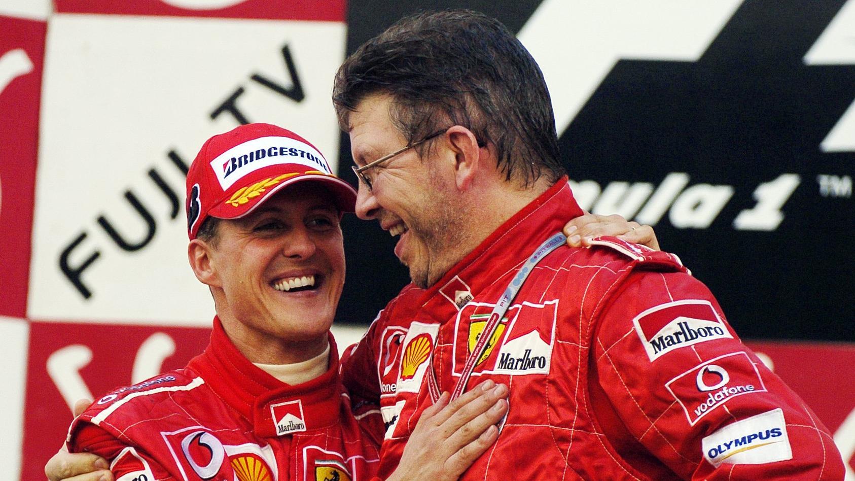 ARCHIV - 09.10.2004, Japan, Suzuka: ARCHIV - Der deutsche Formel-1-Pilot Michael Schumacher (l) jubelt in Suzuka nach seinem Sieg beim Großen Preis von Japan mit Ferrari-Technikchef Ross Brawn (Archivfoto vom 10.10.2004). Foto Oliver Multhaup dpa  ++