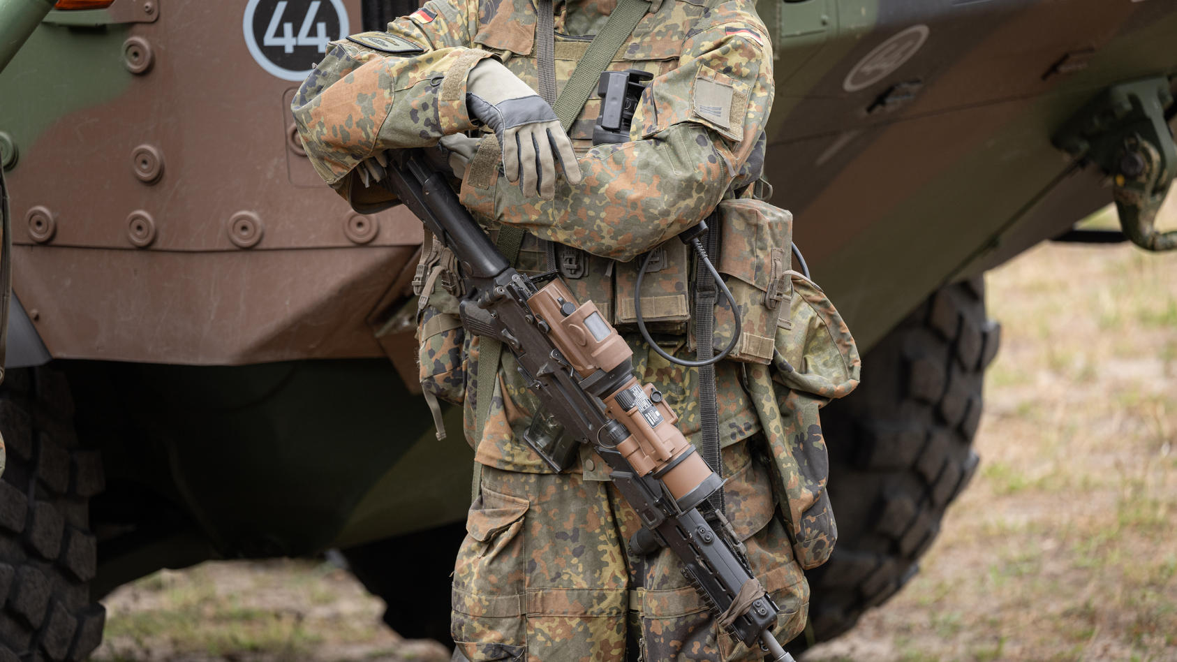 Ein bewaffneter Grenadier im Ausrüstungszustand steht auf dem Bundeswehrgelände in Munster vor einem GTK Boxer.