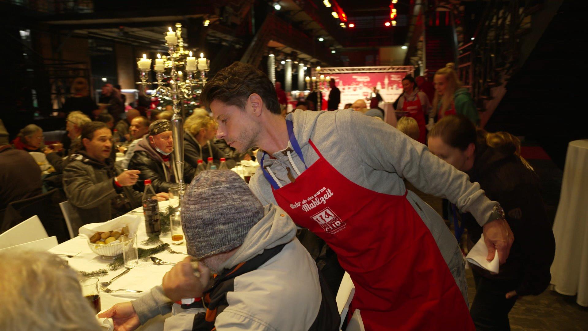 Schauspieler Stephen Dürr verteilt das Weihnachts-Essen an die Bedürftigen.