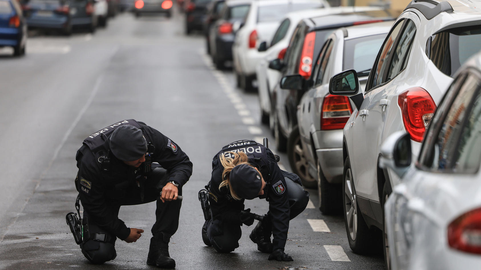 29.11.2022, Nordrhein-Westfalen, Krefeld: Polizisten suchen in der Nähe eines Tatortes nach Spuren. Nach der Erschießung eines 42-Jährigen auf offener Straße fahndet die Mordkommission in Krefeld nach zwei Männern. Foto: Oliver Berg/dpa +++ dpa-Bildf