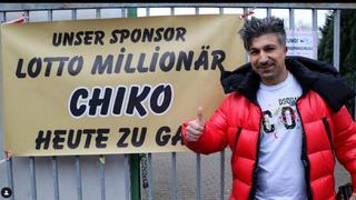 Strahlend steht Chico vor dem Banner des Fußball-Vereins, das seine Anwesenheit ankündigt.