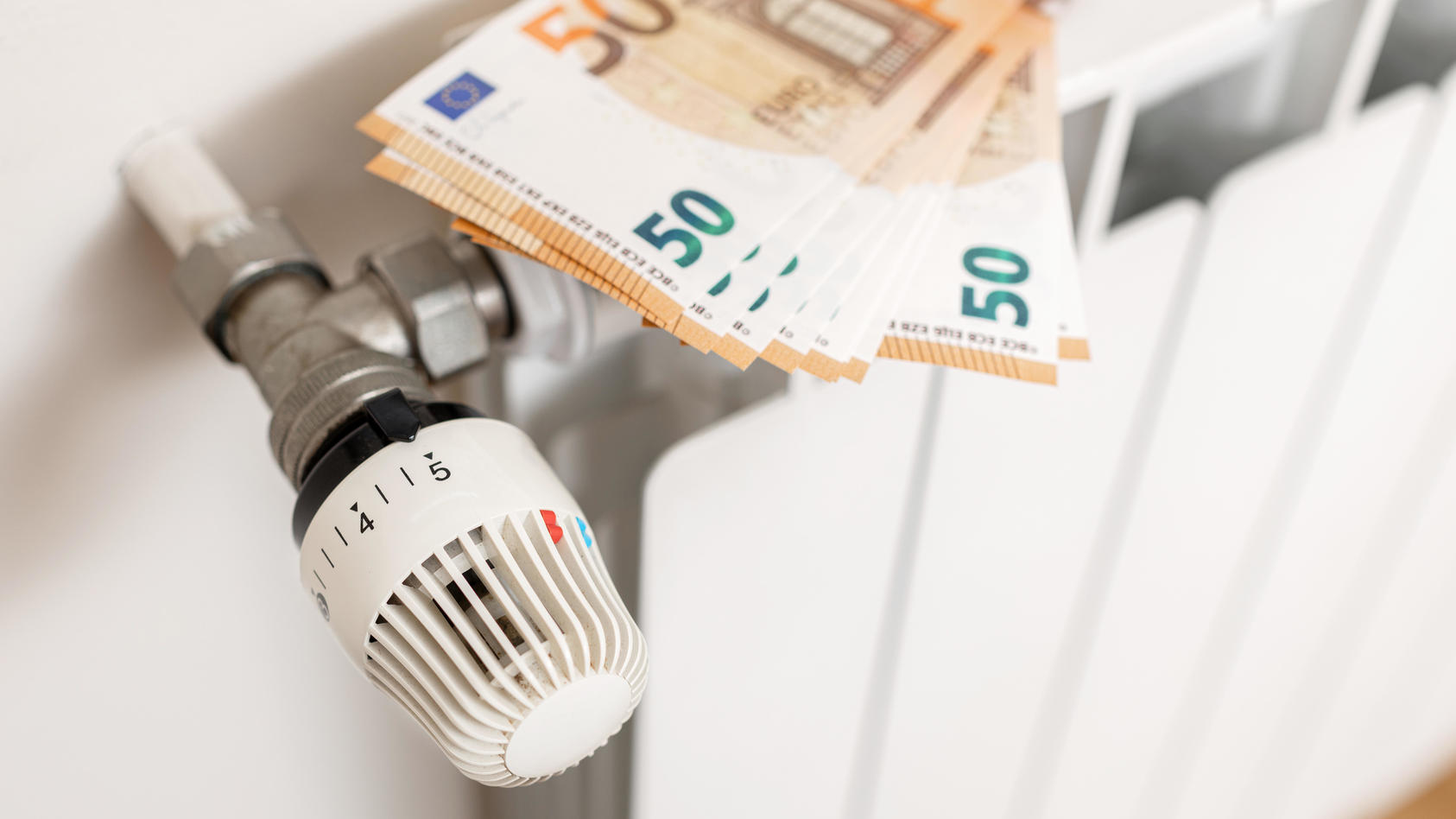 Close up of Euro banknotes on a heating radiator. Energy cost crisis concept