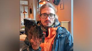 Um diesen Aktivisten zu befreien, mussten Bauarbeiter ein Stück Asphalt aus der Straße flexen.