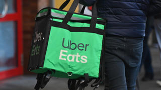 Essenslieferung von Uber Eats: Ein Mann trägt eine Isoliertasche mit warmen Mahlzeiten.