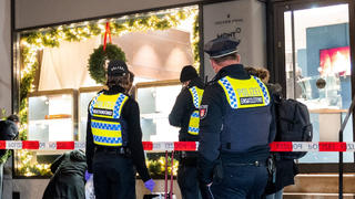20.12.2022, Hamburg: Polizisten stehen nach einem Überfall auf einen Juwelier in der Neustadt vor dem Gebäude. Mehrere Täter haben am Abend das Geschäft überfallen und dabei Schmuck und Uhren in Wert mehrerer Millionen erbeutet. Foto: Daniel Bockwoldt/dpa +++ dpa-Bildfunk +++