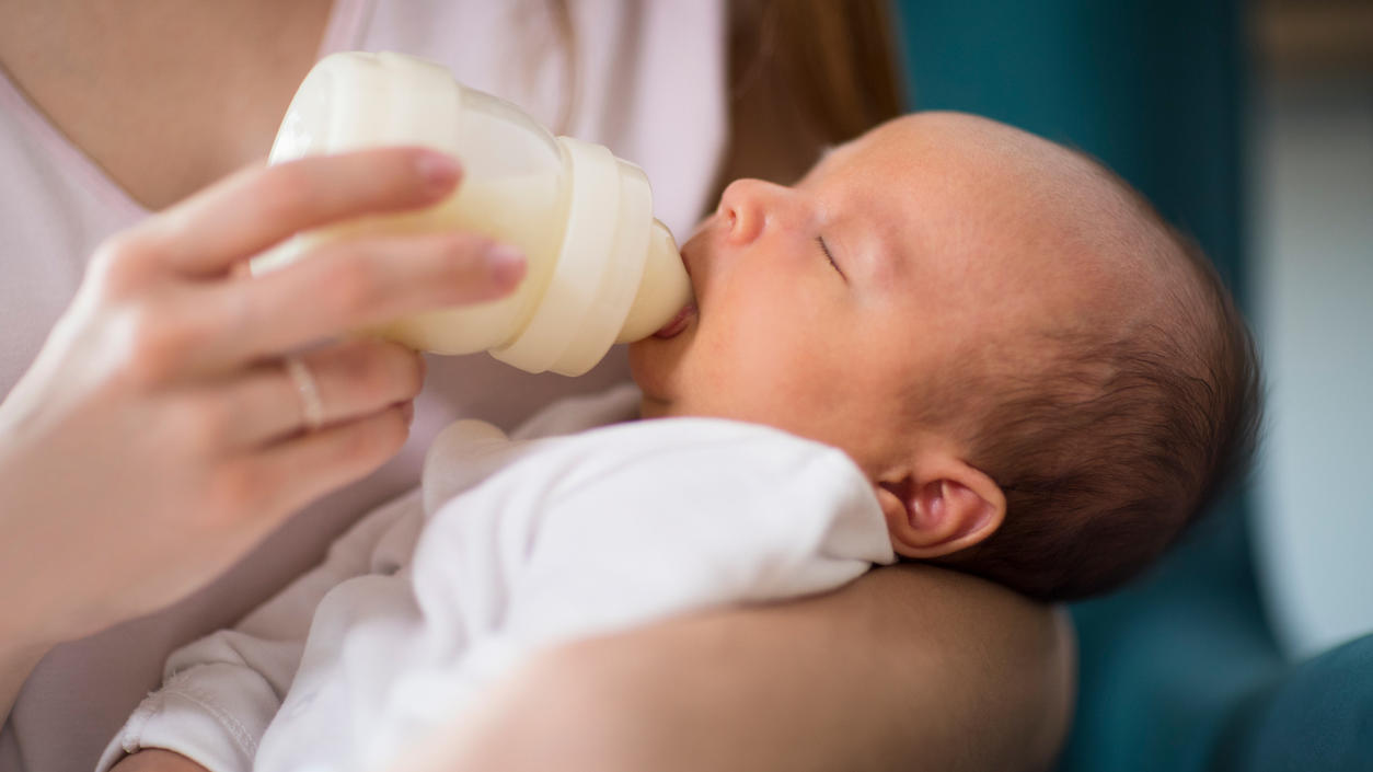 Ein Baby wird mit der Flasche mit Anfangsmilch gefüttert