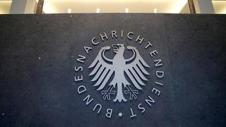 Ein leuchtendes Schild mit dem Logo des Bundesnachrichtendienstes am Hauptquartier.