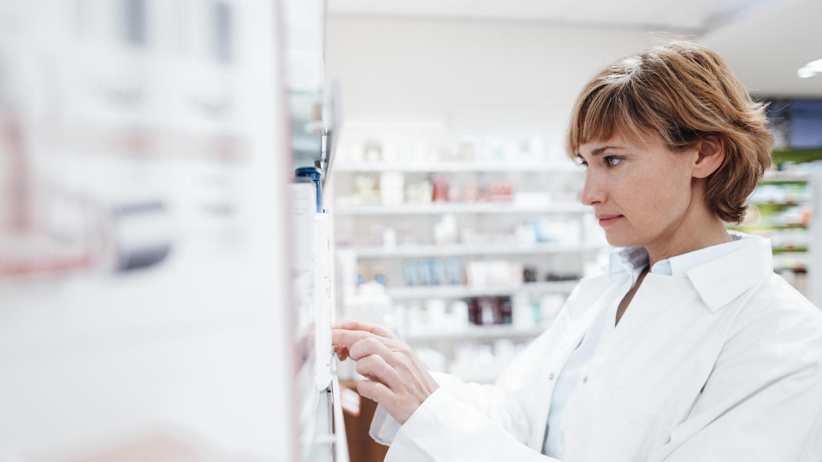  Female pharmacist searching medicine at pharmacy model released Symbolfoto property released JOSEF05446