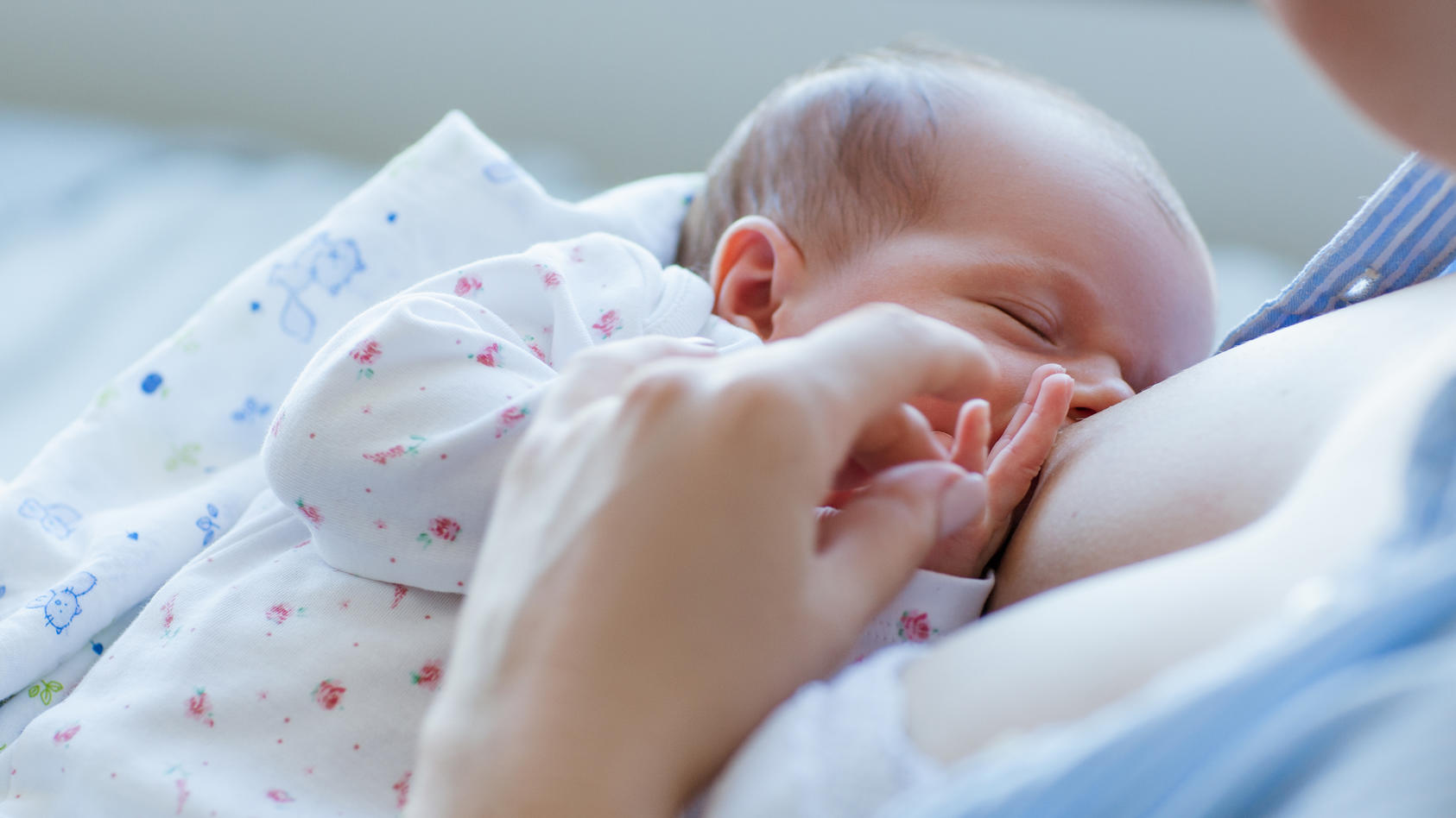 Neugeborenes saugt an Brust der Mutter