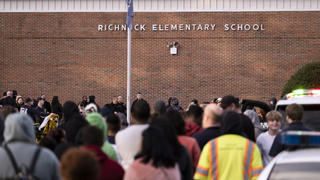 Students and police gather outside of Richneck Elementary School after a shooting, Friday, Jan. 6, 2023 in Newport News, Va. A shooting at a Virginia elementary school sent a teacher to the hospital and ended with â€œan individualâ€ in custody Friday, police and school officials in the city of Newport News said.Â (Billy Schuerman/The Virginian-Pilot via AP)