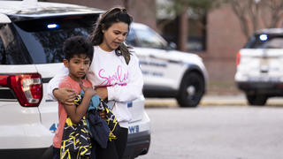 Carlos Glover, age 9,  a fourth grader at Richneck Elementary School, is held by his mother Joselin Glover as they leave the school, Friday, Jan. 6, 2023 in Newport News, Va. A shooting at a Virginia elementary school sent a teacher to the hospital and ended with â€œan individualâ€ in custody Friday, police and school officials in the city of Newport News said.Â (Billy Schuerman/The Virginian-Pilot via AP)