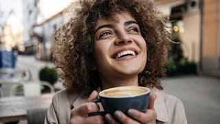 Junge Frau beim Kaffeetrinken