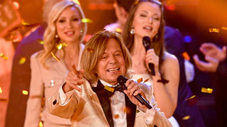 PRODUKTION - 23.10.2022, Sachsen, Leipzig: Der deutsche Schlagersänger Jürgen Drews, seine Frau Ramona (l) und seine Tochter Joelina stehen während der Fernsehshow ·Der große Schlagerabschied· auf der Bühne. Mit der Sendung verabschiedet sich Schlagersänger Jürgen Drews endgültig von der großen Bühne. Foto: Hendrik Schmidt/dpa +++ dpa-Bildfunk +++