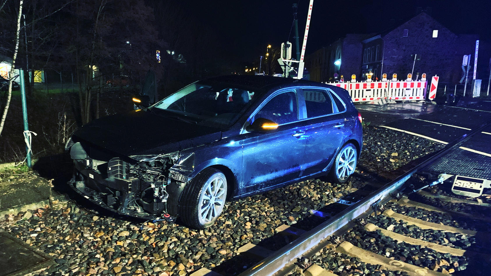 HANDOUT - 14.01.2023, Nordrhein-Westfalen, Stolberg: Ein demoliertes Auto steht neben den Schienen. Bei einem Zusammenstoß eines Autos mit einem Zug sind in Stolberg zwei Menschen verletzt worden. Eine Euregiobahn war am Samstagabend an einem Bahnübe