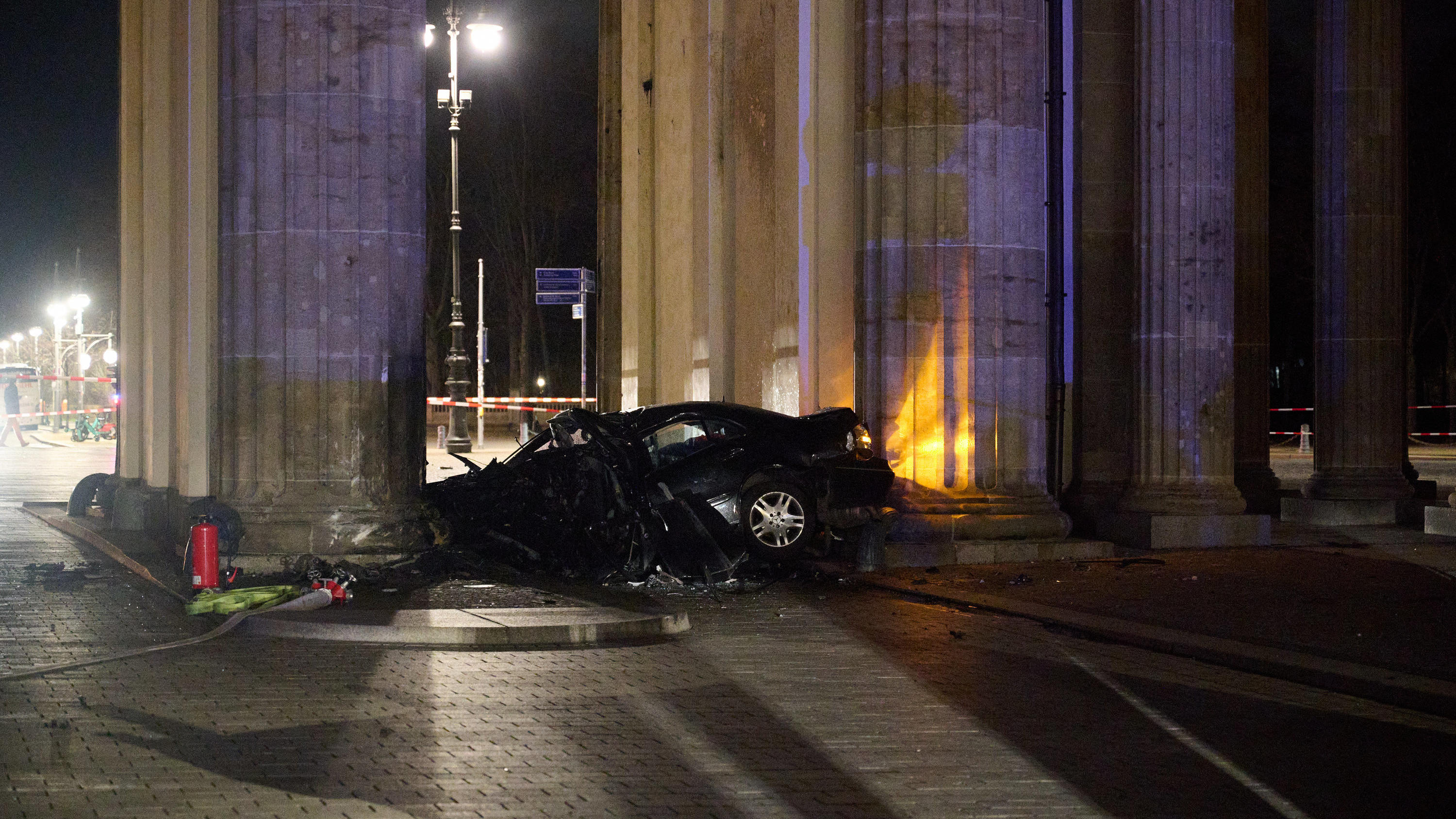 16.01.2023, Berlin: Ein zerstörter PKW liegt zwischen zwei Säulen des Brandenburger Tors. Ein Auto ist gegen eine Säule des Brandenburger Tors in Berlin gefahren. In dem Wagen hätten Feuerwehrleute einen toten Mann gefunden, sagte ein Polizeisprecher