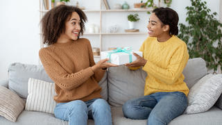 Frau, die Ihrer Schwester ein Geschenk überreicht.