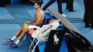 Novak Djokovic sitzt während seines Spiels in der dritten Runde auf der Pausenbank.