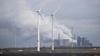 Windkraftanlagen stehen auf einem Feld bei Erkelenz, dahinter das Kohlekraftwerk Neurath von RWE.