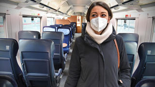 Frau trägt Maske im Zug: Dieser Anblick dürfte in Zügen ab Februar seltener werden