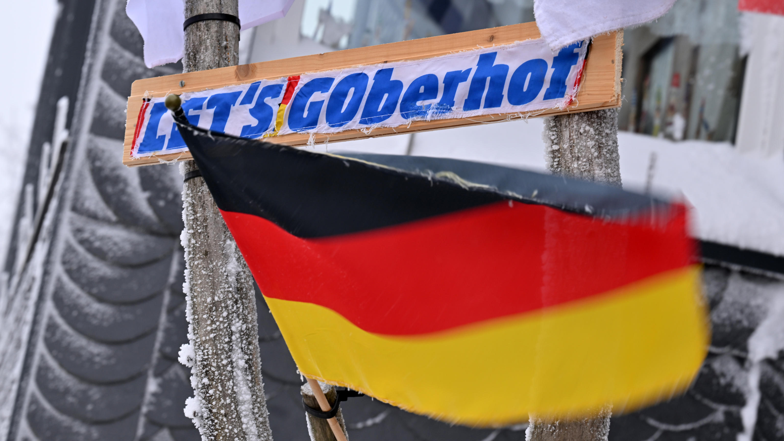 Die ganze Stadt freut sich auf das Sport-Spektakel: "LET'S GOberhof" steht auf dem Schild neben einer Deutschlandfahne an einem Hauseingang in Oberhof.
