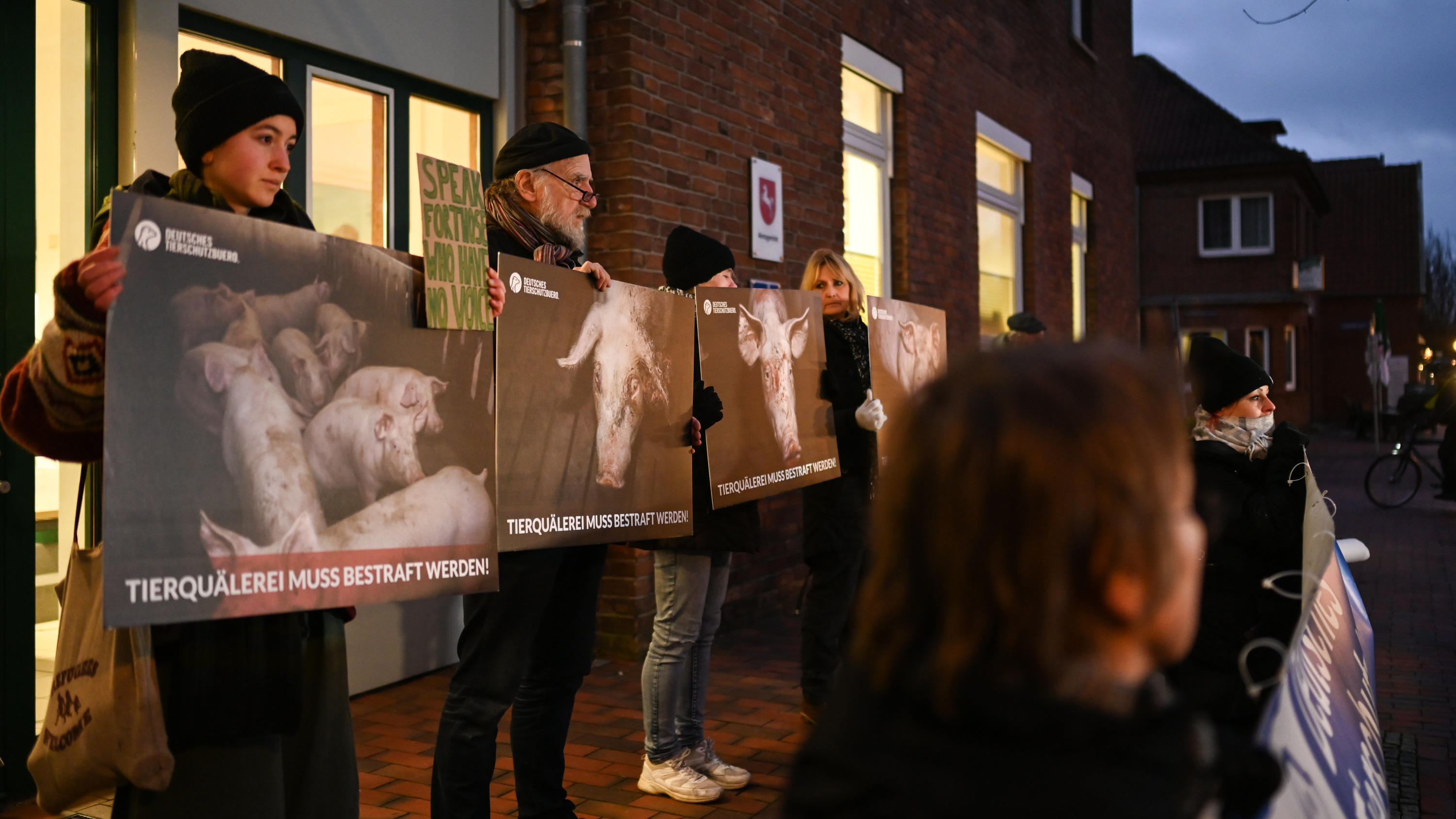 31.01.2023, Niedersachsen, Papenburg: Demonstranten stehen bei einem Protest des Deutschen Tierschutzbüros gegen Tierquälerei vor dem Amtsgericht. Im Zusammenhang mit Tierschutzverstößen in einer Schweinemast im Emsland müssen sich zwei Angeklagte vo