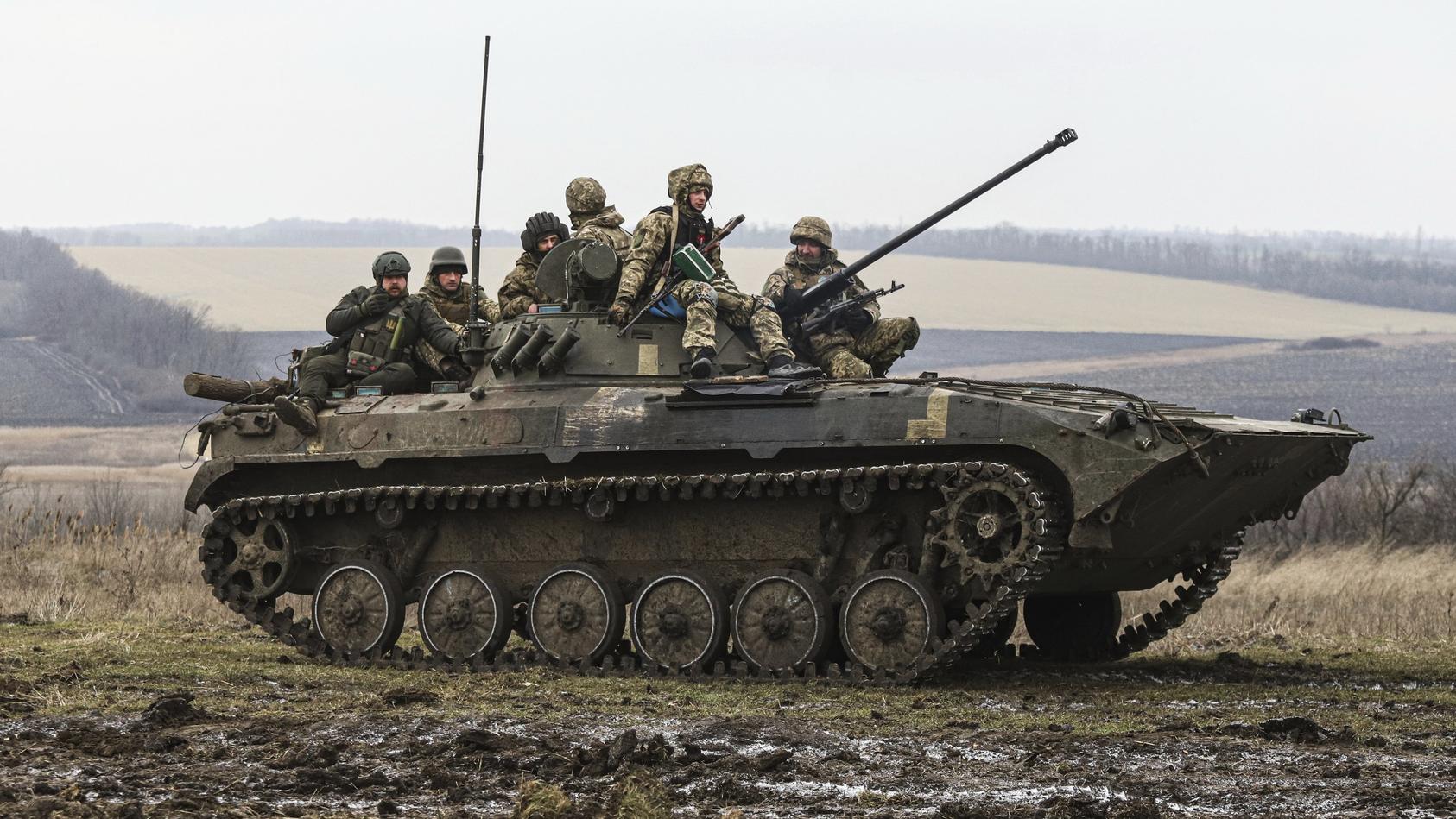 23.01.2023, Ukraine, Saporischschja: Ukrainische Soldaten sitzen während eines Militärtrainings auf einem sogenannten APC, einem gepanzerte Mannschaftstransportwagen. Foto: Kateryna Klochko/AP/dpa +++ dpa-Bildfunk +++