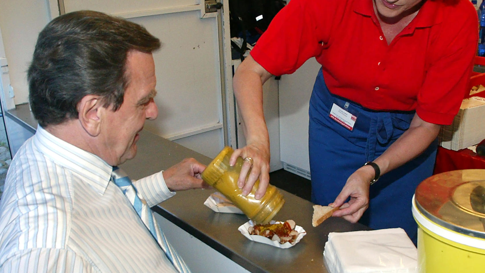 Bundeskanzler Gerhard Schröder läßt sich am Dienstag (28.06.2005) beim Hoffest der SPD in Berlin an einem Currywurststand eine Berliner Spezialität zubereiten.