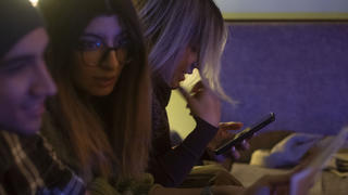 An Iranian young woman uses her smartphone to check her social media pages while waiting for an underground music performance at a cafe in downtown Tehran at night, January 18, 2023. Tehran seems more calm after months of unrest, with youths gathering at cafes, playing music and socializing. (Photo by Morteza Nikoubazl/NurPhoto)