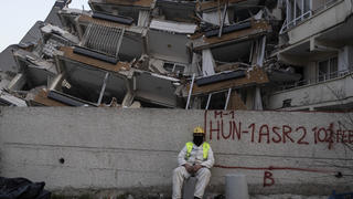 11.02.2023, Türkei, Antakya: Ein Rettungshelfer ruht sich aus, während andere die Suche nach den Opfern des Erdbebens fortsetzen. Die Zahl der Toten nach den verheerenden Erdbeben im türkisch-syrischen Grenzgebiet ist auf mehr als 25 000 gestiegen. Foto: Petros Giannakouris/AP/dpa +++ dpa-Bildfunk +++
