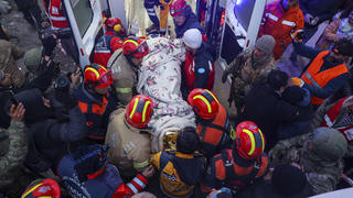 11.02.2023, Türkei, Hatay: Türkische Rettungskräfte tragen Ergin Guzeloglan zu einem Krankenwagen, nachdem sie ihn fünf Tage nach dem Erdbeben aus einem eingestürzten Gebäude herausgezogen haben. Vier Tage nach dem katastrophalen Erdbeben in der Türkei und in Syrien haben Rettungskräfte am 10.02.2023 in der Türkei eine Reihe dramatischer Rettungsaktionen durchgeführt und mehrere Menschen aus den Trümmern befreit, von denen einige fast unversehrt geblieben sind Foto: Can Ozer/AP/dpa +++ dpa-Bildfunk +++