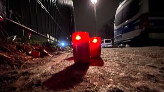 21.02.2023, Berlin: Brennende Kerzen stehen an einem Park in Pankow neben Polizeifahrzeugen. Das vermisste vierjährige Mädchen aus Berlin ist tot. Es sei am Abend mit Verletzungen von Passanten im Bürgerpark Pankow gefunden worden, sagte ein Polizeisprecher. Rettungskräfte hätten versucht, das Kind zu reanimieren. Es sei dann im Krankenhaus verstorben. Ein 19 Jahre alter Tatverdächtiger sei bereits festgenommen worden. (Zu dpa «Vermisste Vierjährige in Berlin tot - Polizei vermutet Tötungsdelikt») Foto: Paul Zinken/dpa +++ dpa-Bildfunk +++