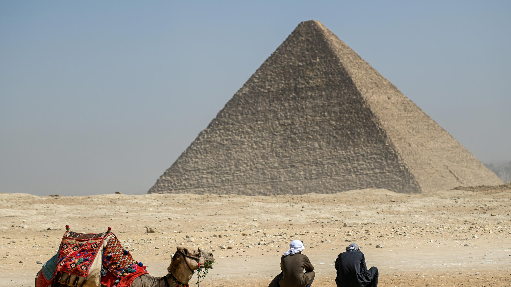 Ein Kamel und seine Reiter rasten vor der Großen Pyramide von Gizeh. Ein internationales Forschungsteam hat in der berühmten ägyptischen Cheops-Pyramide von Gizeh eine bisher unbekannte Kammer nachgewiesen. 