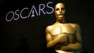 ARCHIV - 04.02.2019, USA, Beverly Hills: Eine Oscar-Statue steht beim 91. Oscar-Nominierten-Lunch vor dem Schriftzug. Hollywood im Fernsehen: ProSieben überträgt in einer Woche wieder die Verleihung der Academy Awards live aus Los Angeles und hat dieses Jahr etwas zu feiern. Denn es ist das 25. Mal, dass der deutsche Sender vom Roten Teppich vor dem Dolby Theatre sendet. Moderieren wird erneut Steven Gätjen - zum 21. Mal. (zu dpa: Jubiläum am Roten Teppich: Zum 25. Mal Oscar-Verleihung auf ProSieben) Foto: Danny Moloshok/Invision/AP/dpa +++ dpa-Bildfunk +++