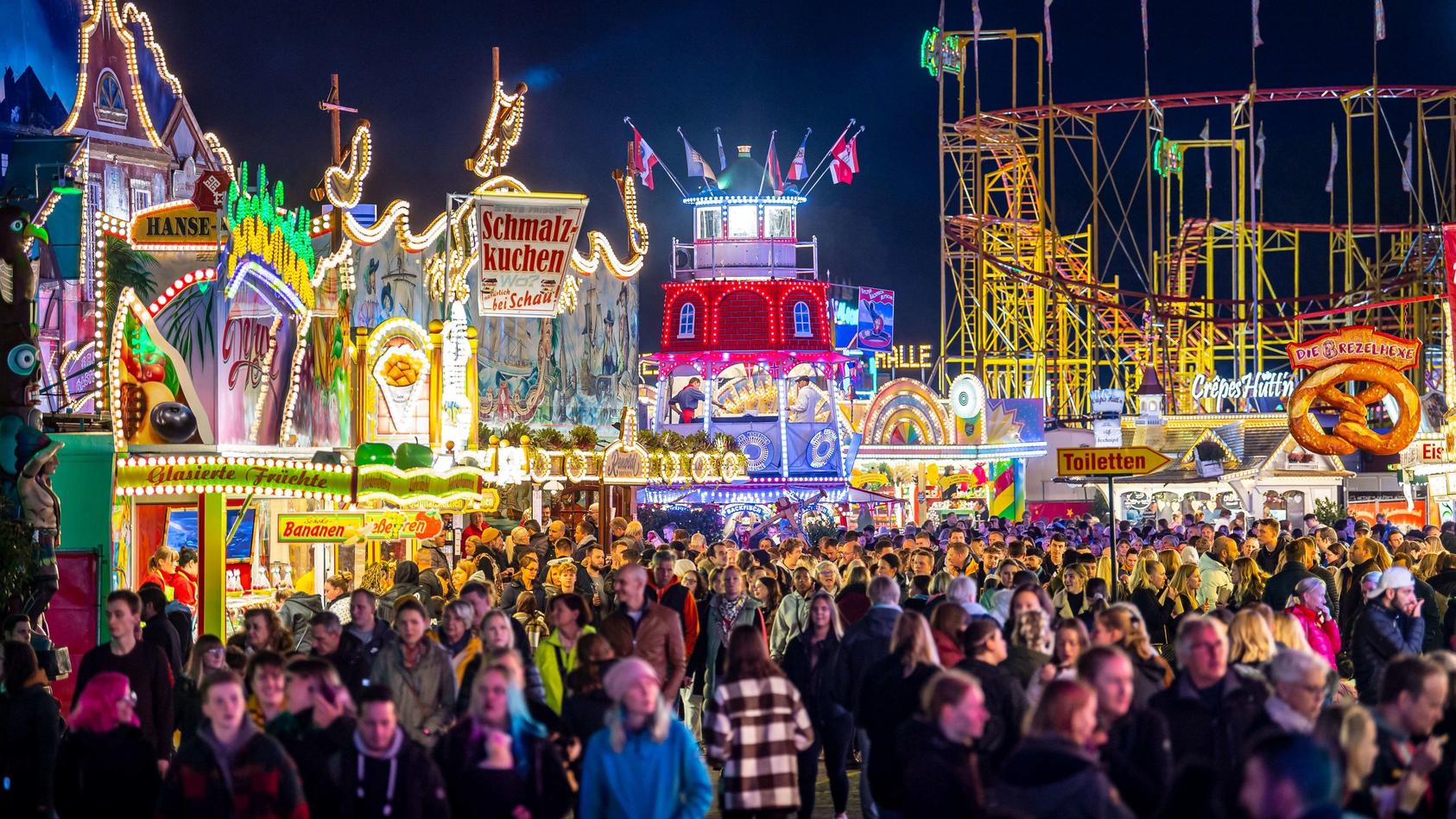 ARCHIV - 14.10.2022, Bremen: Die Fahrgeschäfte auf dem Freimarkt auf dem Bürgerweide leuchten mit bunten Lichtern und Reklameschriftzügen. Der Bremer Freimarkt ist eines der ältesten Volksfeste Deutschlands und das größte im Norden. (zu dpa "Schauste