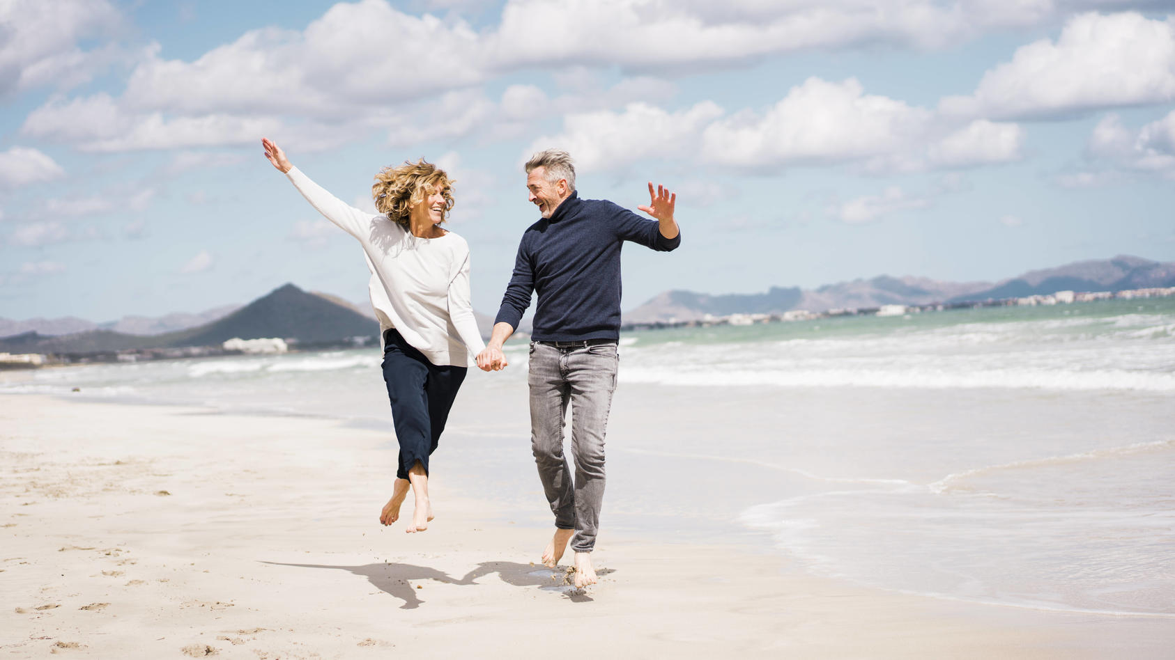 Cheerful mature couple having fun on shore at beach model released, Symbolfoto, JOSEF11419