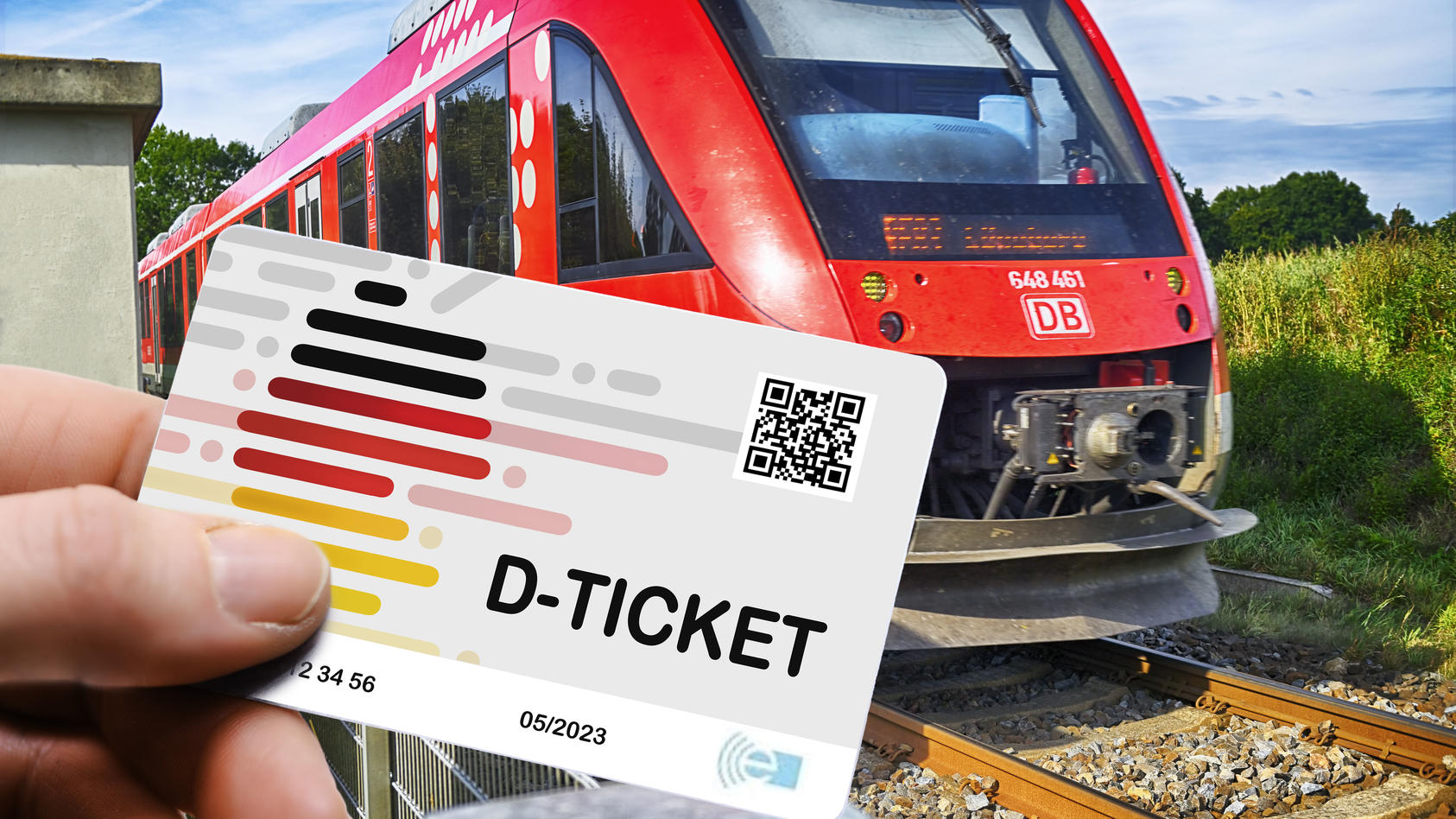 Hand hält das Deutschlandticket D-Ticket vor einer Regionalbahn / action press