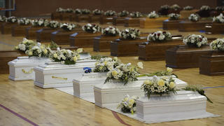 28.02.2023, Italien, Crotone: Die Särge der Opfer eines Bootsunglücks stehen mit Blumen bedeckt in der örtlichen Sporthalle. Bei einem Bootsunglück vor der italienischen Küste sind über 60 Migranten gestorben und Dutzende werden vermisst. Foto: Antonino D'Urso/LaPresse/AP/dpa +++ dpa-Bildfunk +++