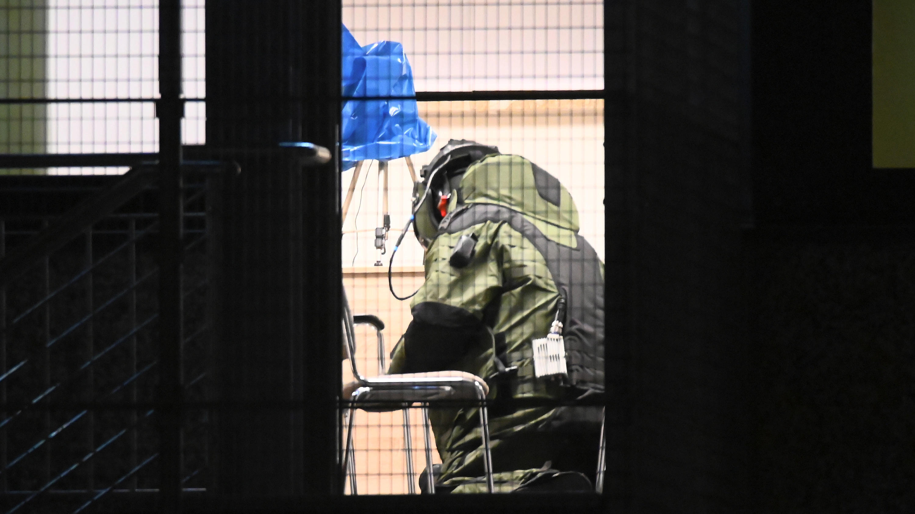 Ein Bombenentschärfer der Polizei Hamburg arbeitet in voller Schutzkleidung in einem Gebäude der Zeugen Jehovas in Hamburg. 