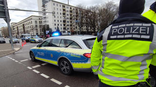 10.03.2023, Karlsruhe: Polizeifahrzeuge stehen auf einer Straße In Karlsruhe. Die Polizei wegen einer Geiselnahme in einem Großeinsatz. Das Tatgeschehen laufe noch, sagte ein Sprecher am frühen Freitagabend der Deutschen Presse-Agentur. In einer Apotheke seien eine oder mehrere Geiseln genommen worden. Foto: Thomas Riedel/-/dpa +++ dpa-Bildfunk +++