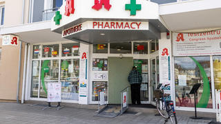 11.03.2023, Baden-Württemberg, Karlsruhe: Ein Mann blickt durch das Fenster der Congress-Apotheke. Am Vorabend hat ein 20-jähriger Täter in der Karlsruher Congress-Apotheke mehrere Geiseln genommen. Kurz nach 21 Uhr haben dann Spezialkräfte der Polizei die Apotheke betreten und den Mann festgenommen. Foto: Philipp von Ditfurth/dpa +++ dpa-Bildfunk +++